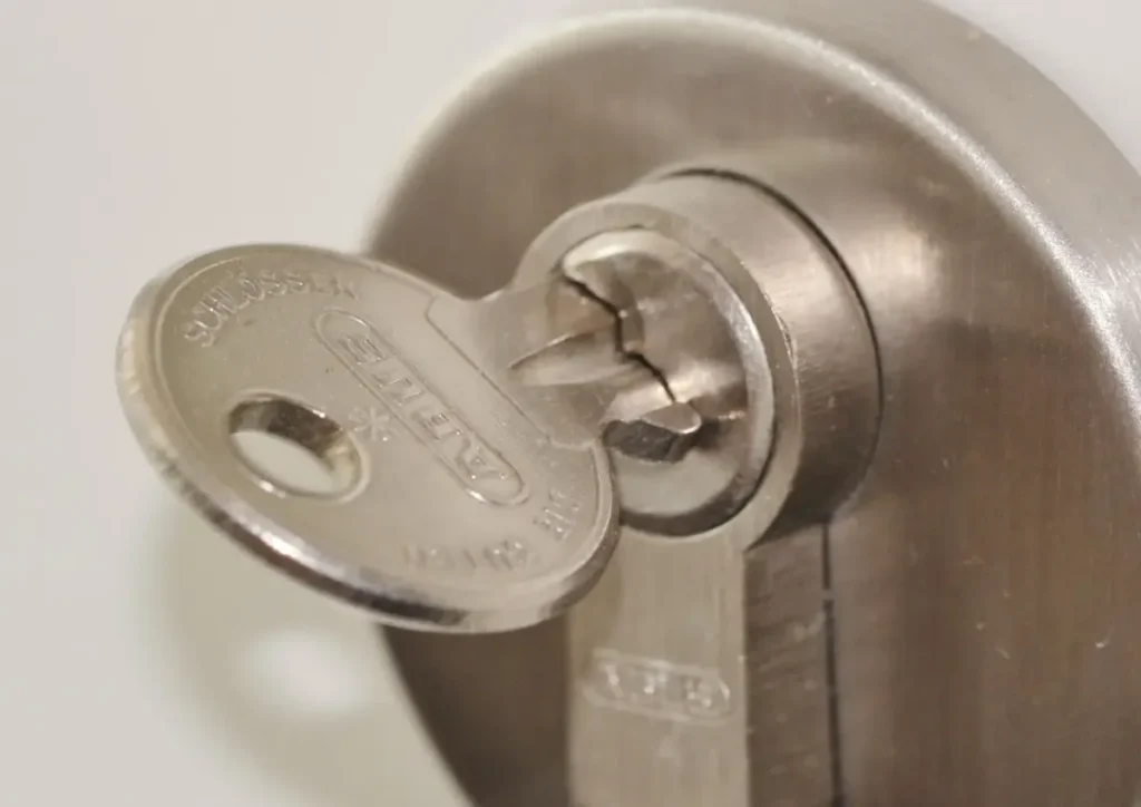 Key inserted in a door lock cylinder – how to choose a trustworthy locksmith in Chester before a lock is drilled or replaced, Locksmith Chester